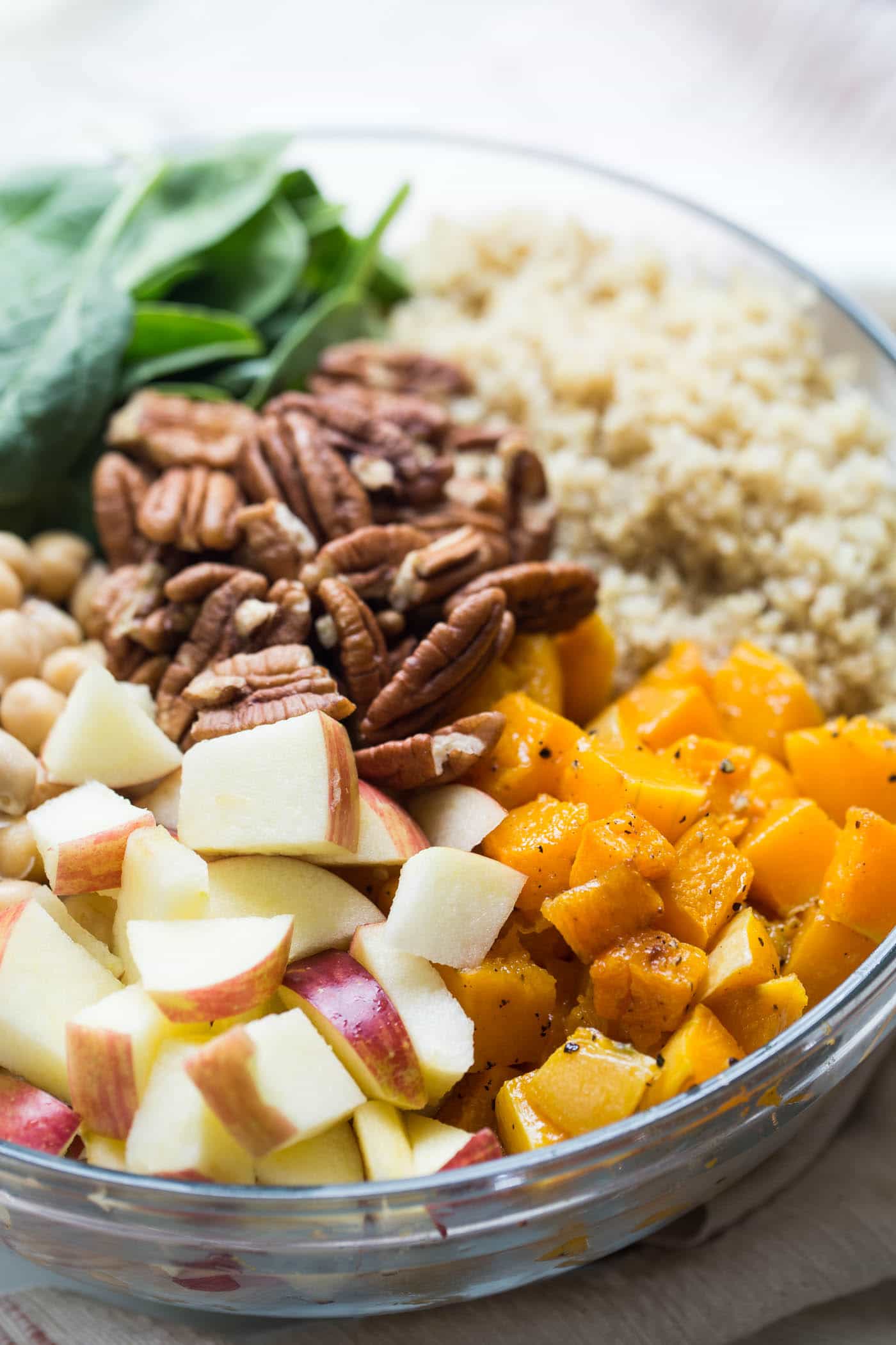 Apples, butternut squash, quinoa, and walnuts in a bowl 