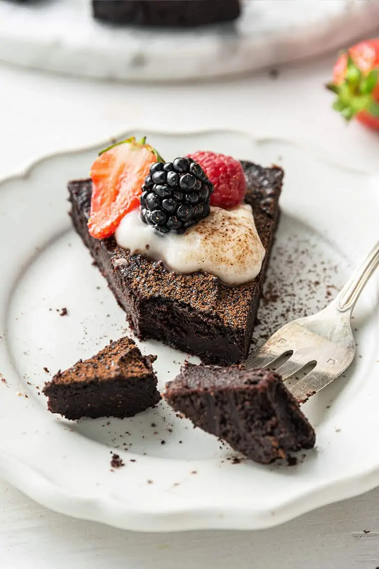 A bite of flourless dark chocolate cake on a fork
