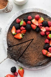 A slice being removed from a flourless dark chocolate cake