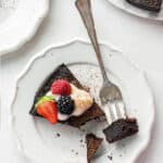 Aerial view of a bite of flourless dark chocolate cake on a fork