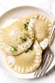 Homemade butternut-spinach ravioli on a serving plate.