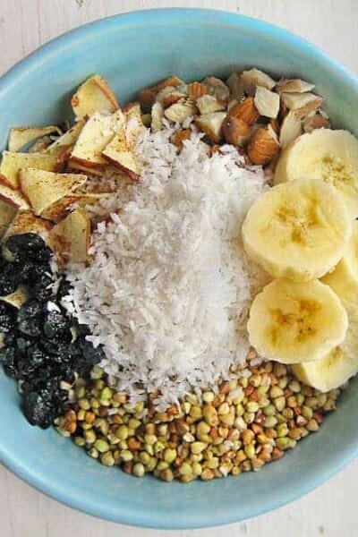 Breakfast cereal bowl with banana slices, shredded coconut, and almonds.