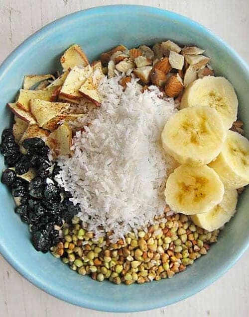 Breakfast cereal bowl with banana slices, shredded coconut, and almonds.