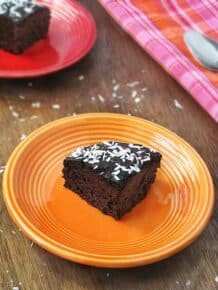 Slice of quinoa chocolate cake on an orange plate.