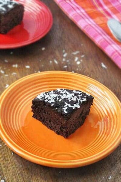 Slice of quinoa chocolate cake on an orange plate.