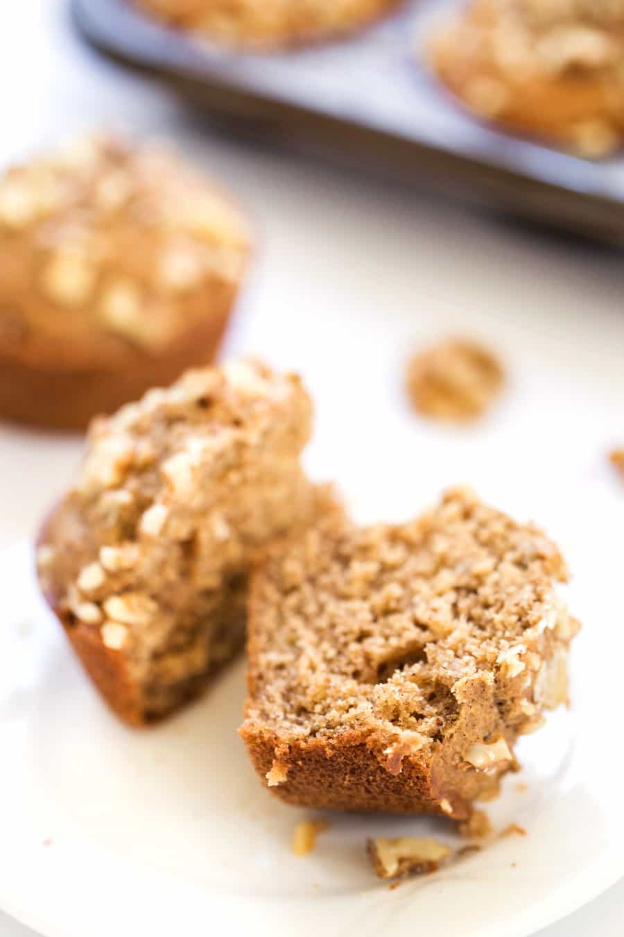 A banana muffin on a plate, cut in half.