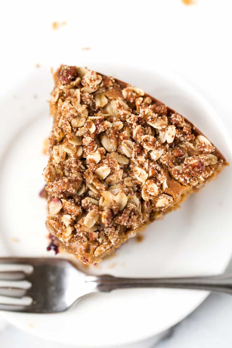 Loaded with juicy fruit and topped with the best pecan crumble, this gluten-free lemon blueberry coffee cake is almost too good to be true. Overhead image of a slice of lemon blueberry coffee cake on a plate with a bite taken out of it.