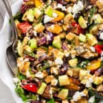 close up on a large bowl of grilled vegetable salad with tahini dressing and feta cheese