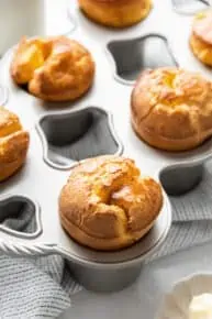 Close up of a gluten-free popover still in the popover pan, with other popovers in the pan in the background