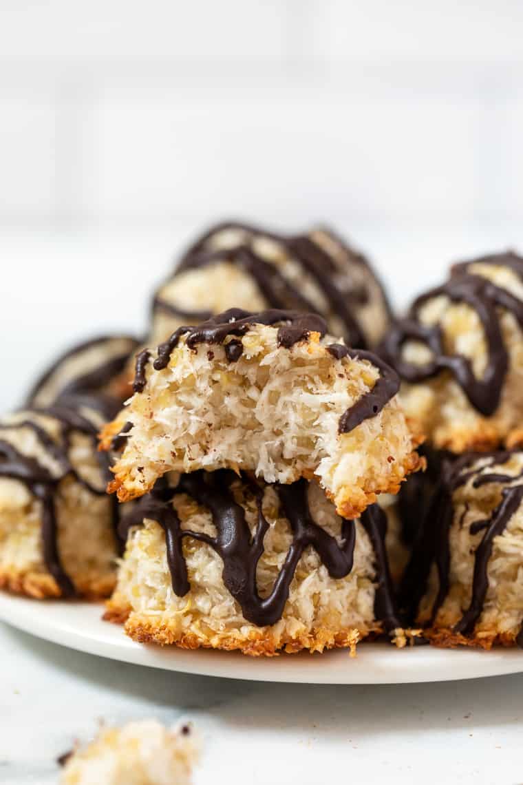 These quinoa coconut macaroons are easy and delicious! They’re sweetened with honey for a fantastic flavor. No condensed milk needed! Stack of quinoa coconut macaroons on plate with one bitten into