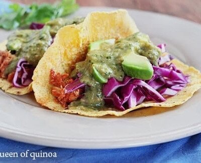 Chicken taco with avocado and onion slices.