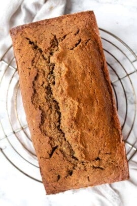 Loaf of gluten-free zucchini bread on wire rack.