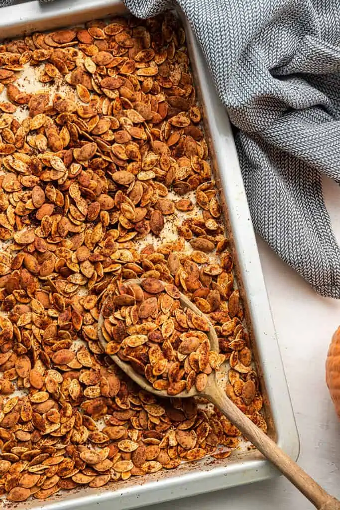 Tray of chili roasted pumpkin seeds with a spoon