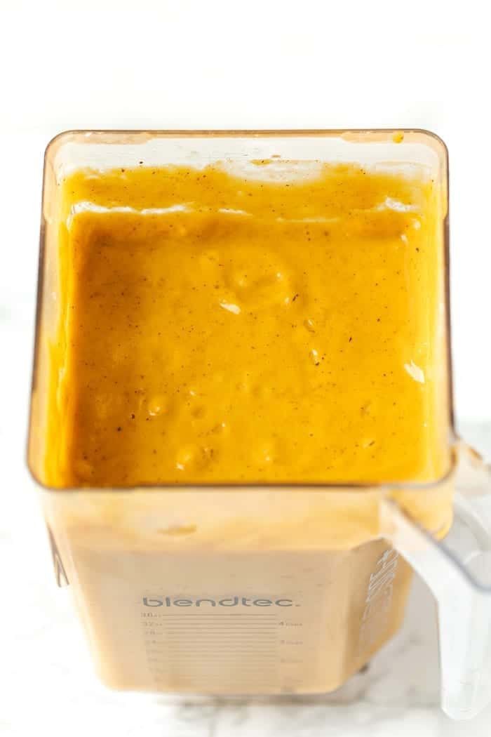 A blender filled with roasted pumpkin soup