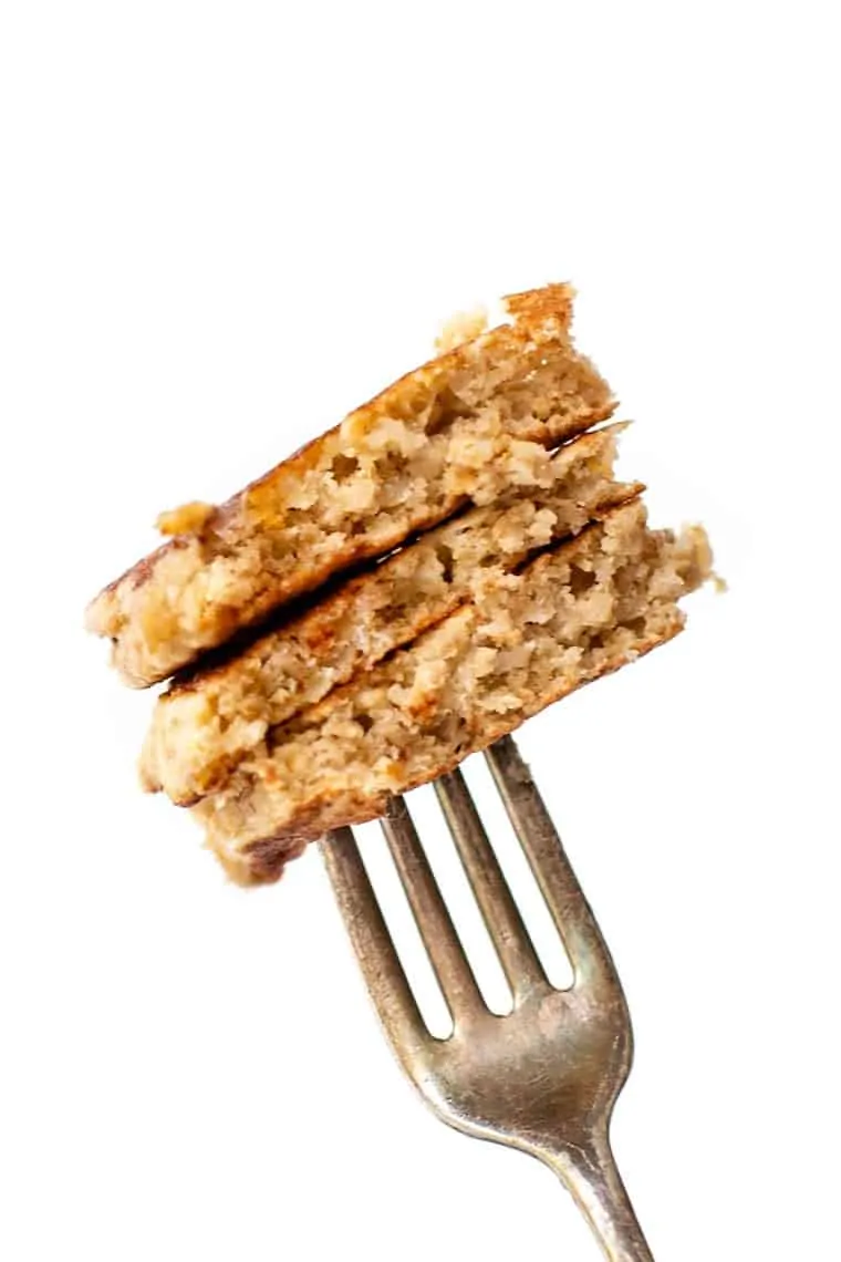 Fork holding 3 stacked pieces of quinoa banana pancakes