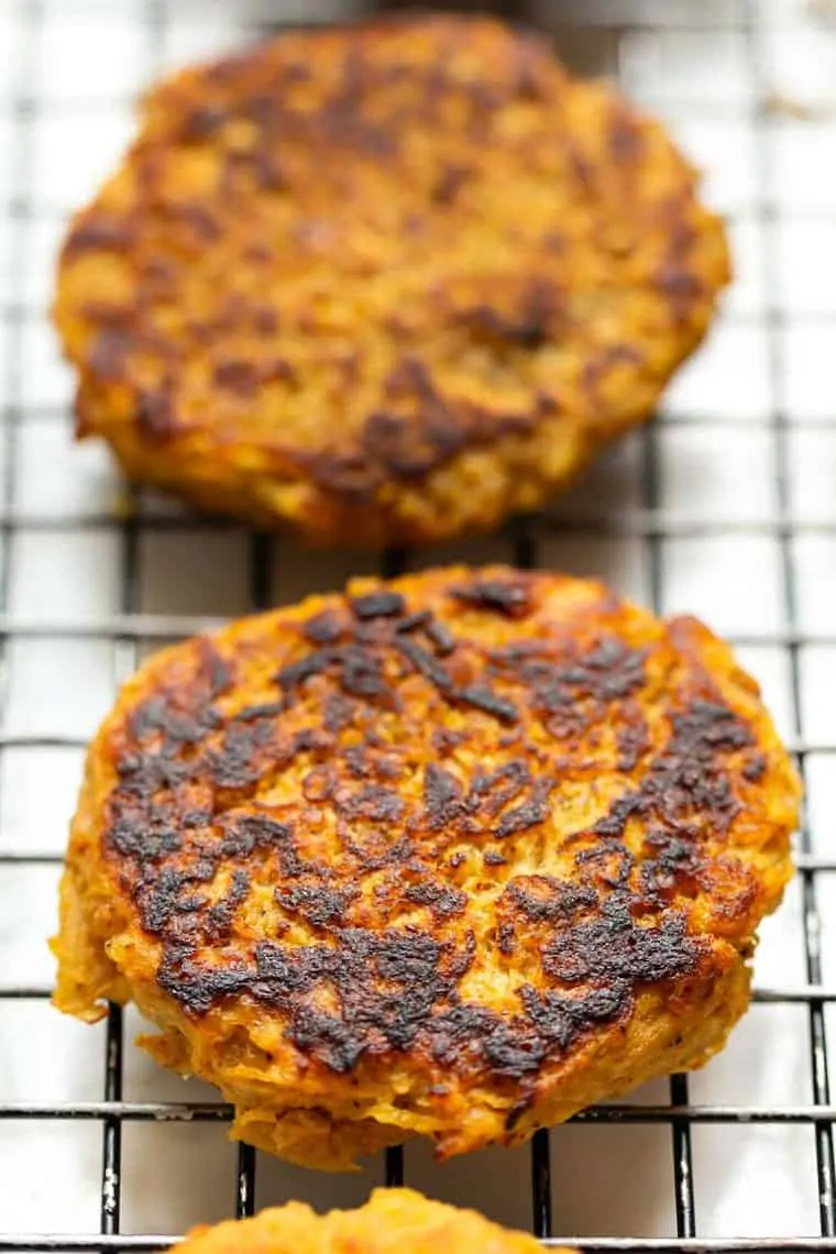 Close up of two spaghetti squash fitters on a wire rack.