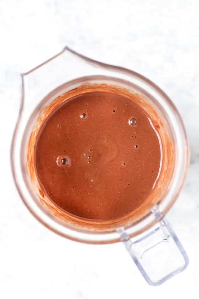 This chocolate strawberry smoothie is tastes like chocolate-covered strawberries! It's packed with frozen berries, cocoa, and hemp seeds. Overhead view of a chocolate strawberry smoothie in a blender.