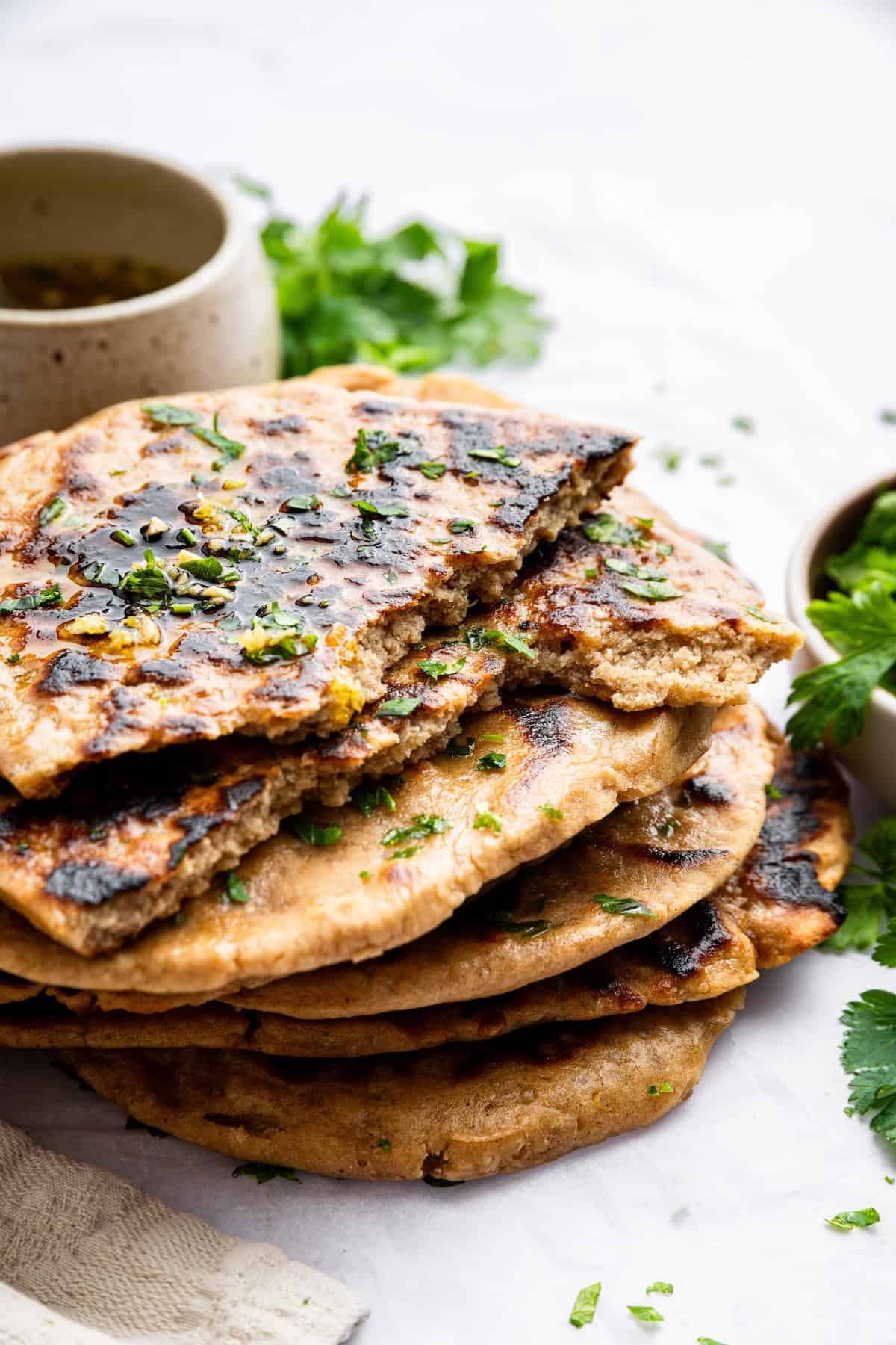 This easy gluten-free naan recipe is made with quinoa and quinoa flour. It's perfect for scooping up all your favorite Indian dishes! Stack of homemade gluten-free naan
