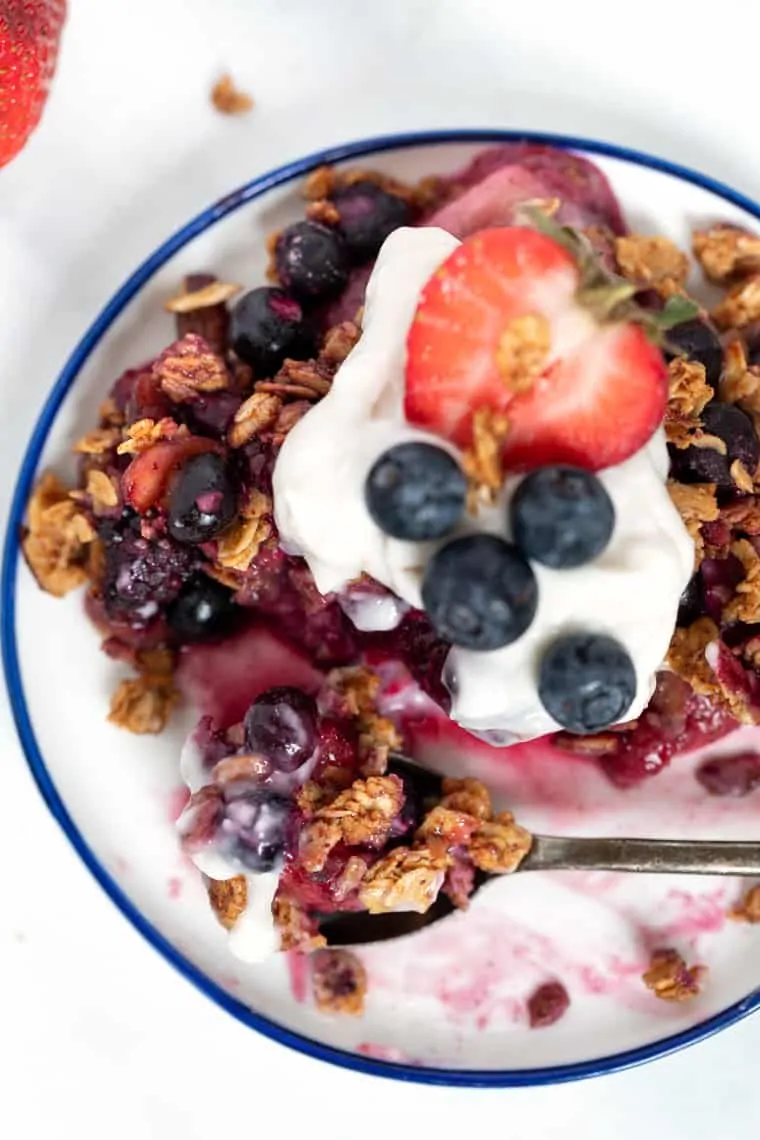 A collection of the best berry recipes—smoothies, breakfasts, salads, desserts and more! Plus tips + tricks for berry picking and storage. Plate of Berry Crumble with Coconut Yogurt
