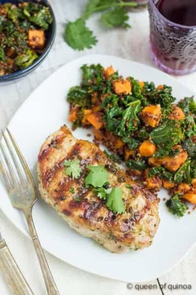 Grilled pork chop on a plate with red quinoa salad.