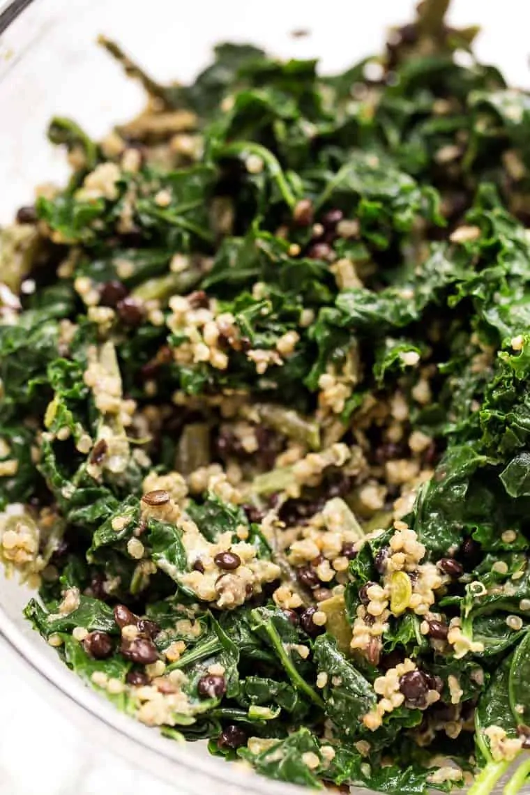 Kale quinoa salad ingredients combined in a large bowl.