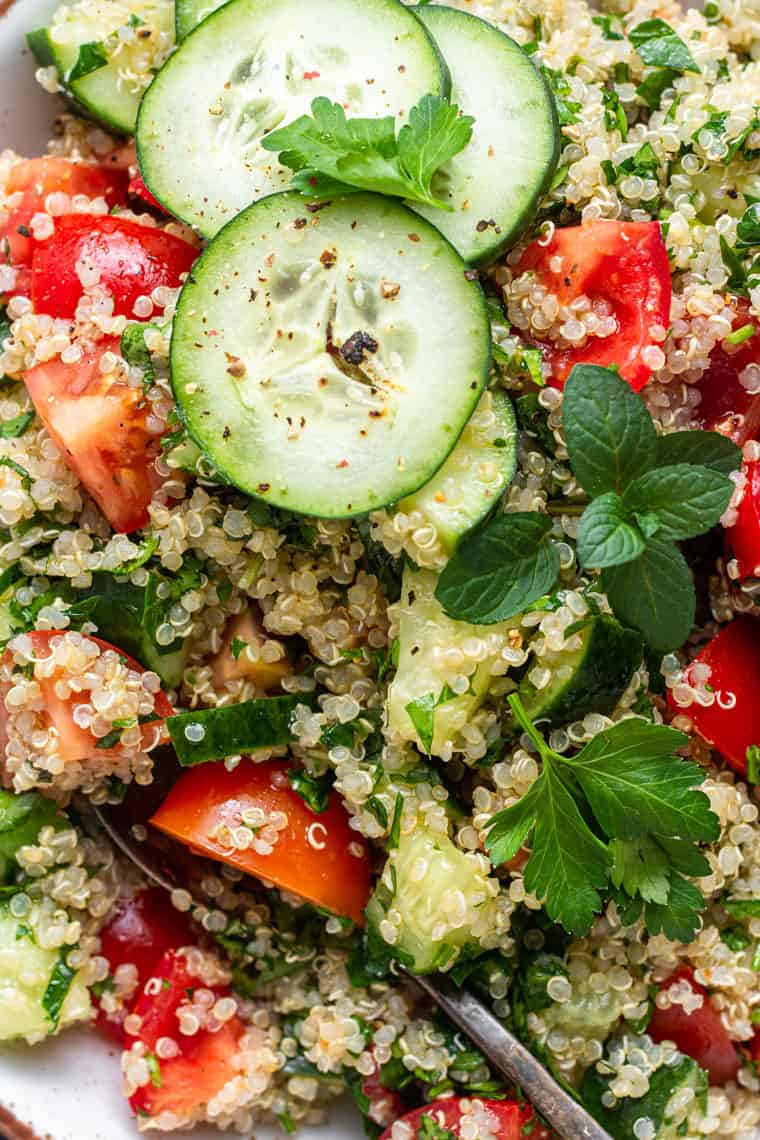 This healthy quinoa tabbouleh salad is light, refreshing, and flavorful. It's also quick and easy, requiring only a few simple ingredients! close up on quinoa tabbouleh salad with tomatoes and cucumbers