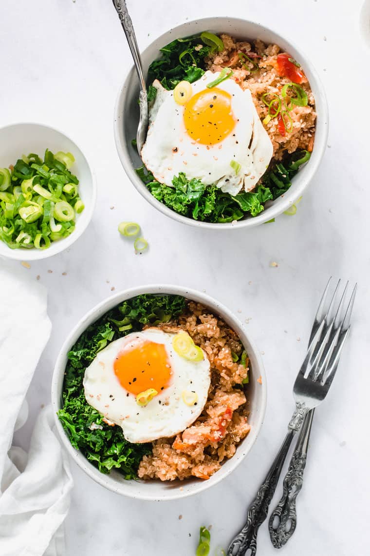 two bowls of kimchi quinoa with a fried egg on top