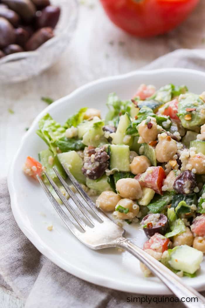 This Chopped Quinoa Salad has tomatoes, cucumbers, olives, romaine and chickpeas and is dressing in a simple chive-tahini dressing | simplyquinoa.com