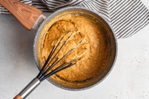 pot of quinoa pumpkn porridge with a whisk