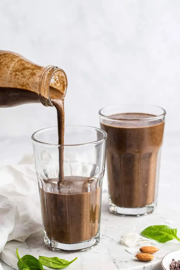 pouring an almond joy smoothie into a glass