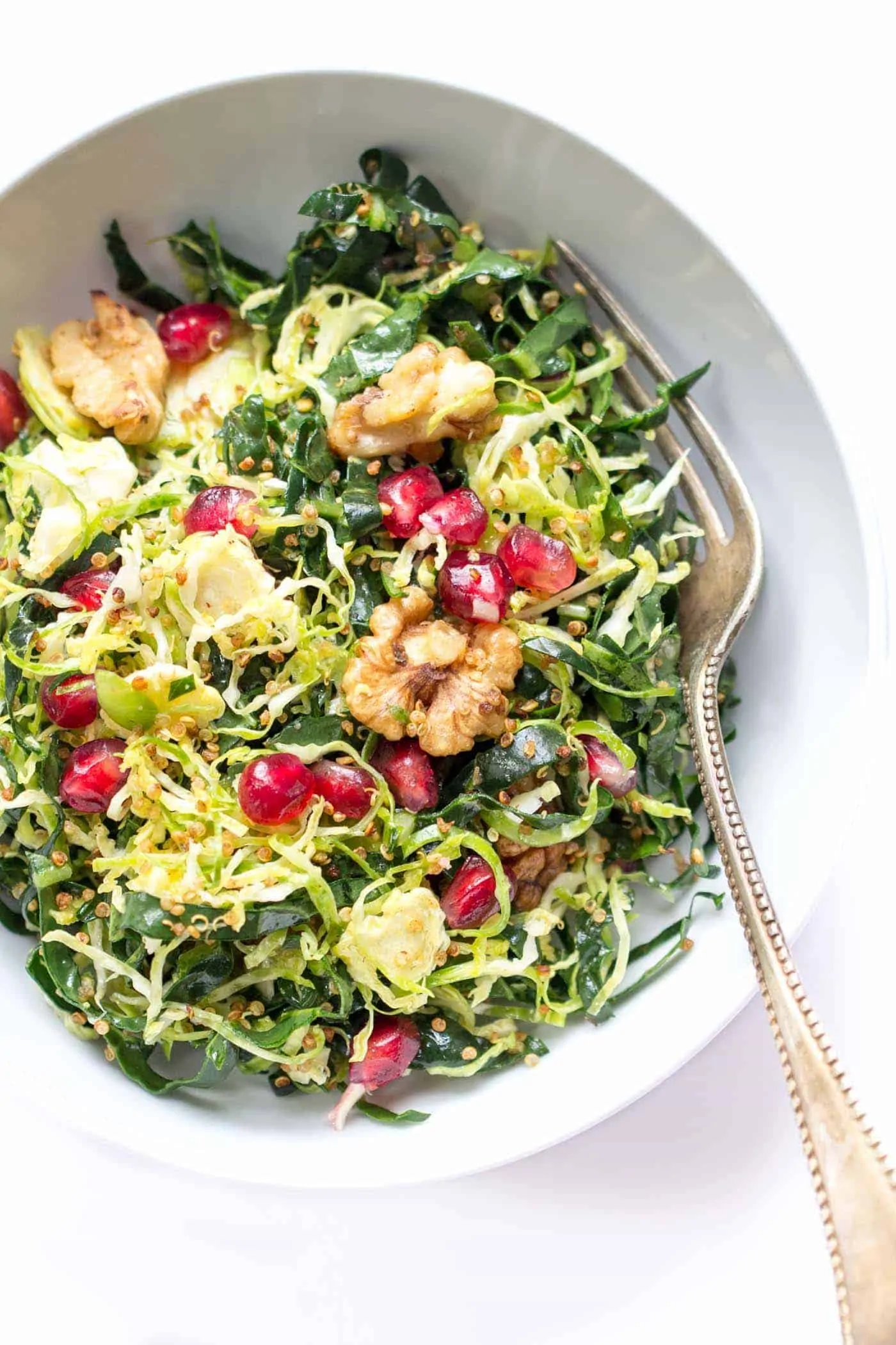 Kale + Shredded Brussels Sprout Quinoa Salad with pomegranates and toasted walnuts -- quick, easy and perfect for detoxing during the holidays!