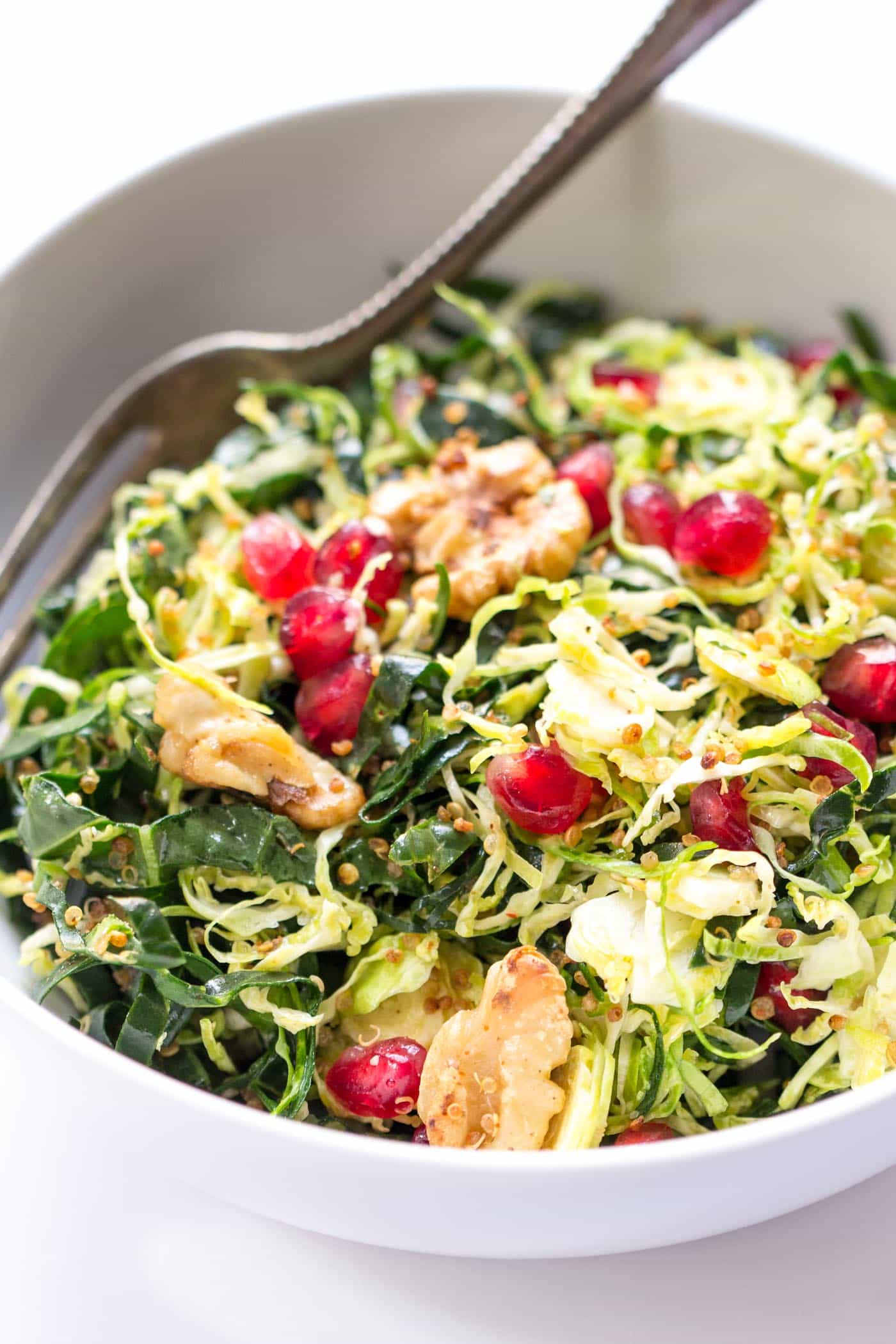 Kale + Shredded Brussels Sprout Quinoa Salad with pomegranates and toasted walnuts -- quick, easy and perfect for detoxing during the holidays!