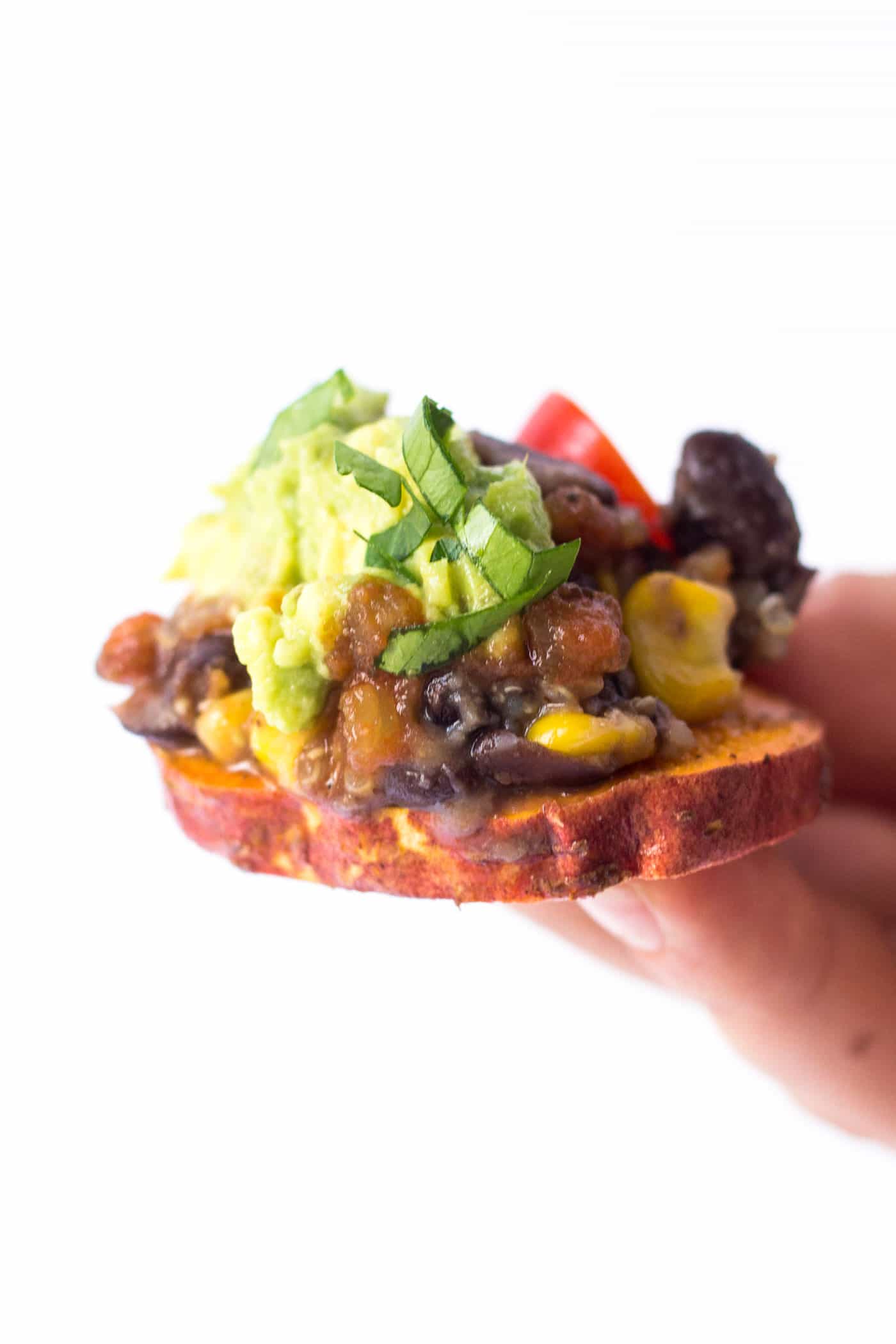 The BEST DAMN vegan nachos ever! Made with sweet potatoes, quinoa, black beans and topped with salsa + guac!