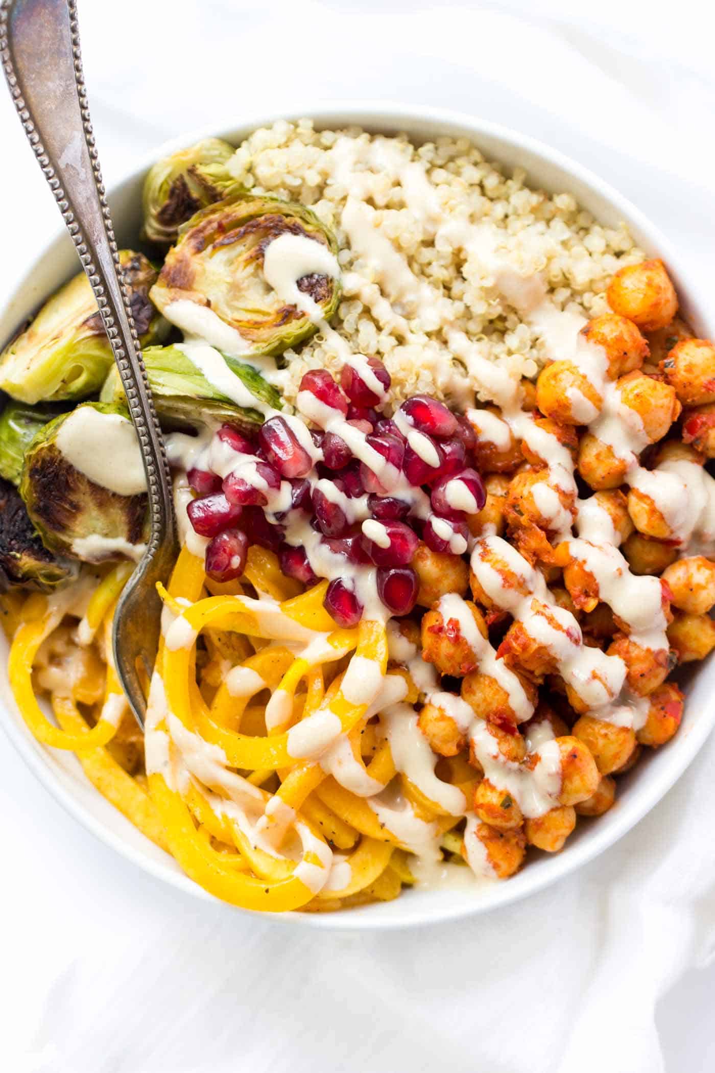 These WARM quinoa bowls use spiralized butternut squash, roasted brussels sprouts and harissa spiced chickpeas - easy, nutritious and healthy! 