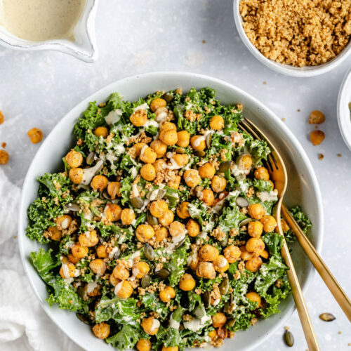 overhead of a white bowl with vegan caesar kale salad with crispy chickpeas and tahini dressing