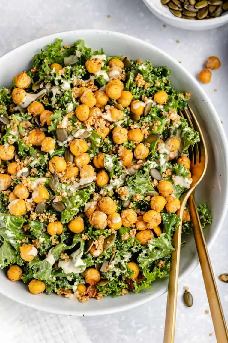 overhead of a white bowl with vegan caesar kale salad with crispy chickpeas and tahini dressing