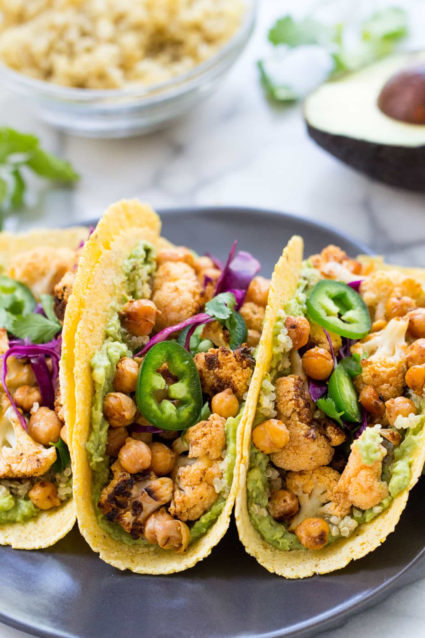 A super HEALTHY vegan taco recipe >> Buffalo Cauliflower + Quinoa Tacos with guac, chickpeas and shredded cabbage on top!