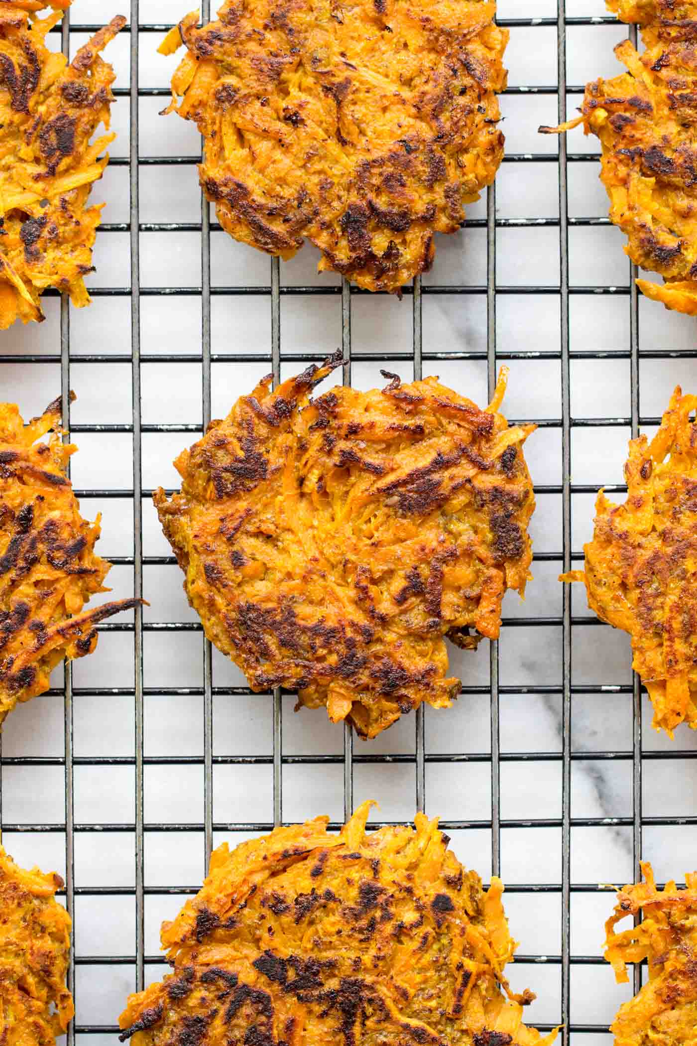 These EASY sweet potato fritters are flavored with curry powder and lightened up with the addition of carrots + quinoa flour!