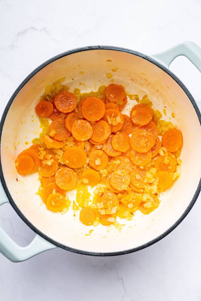 Carrots sauteeing in pot with onions and garlic