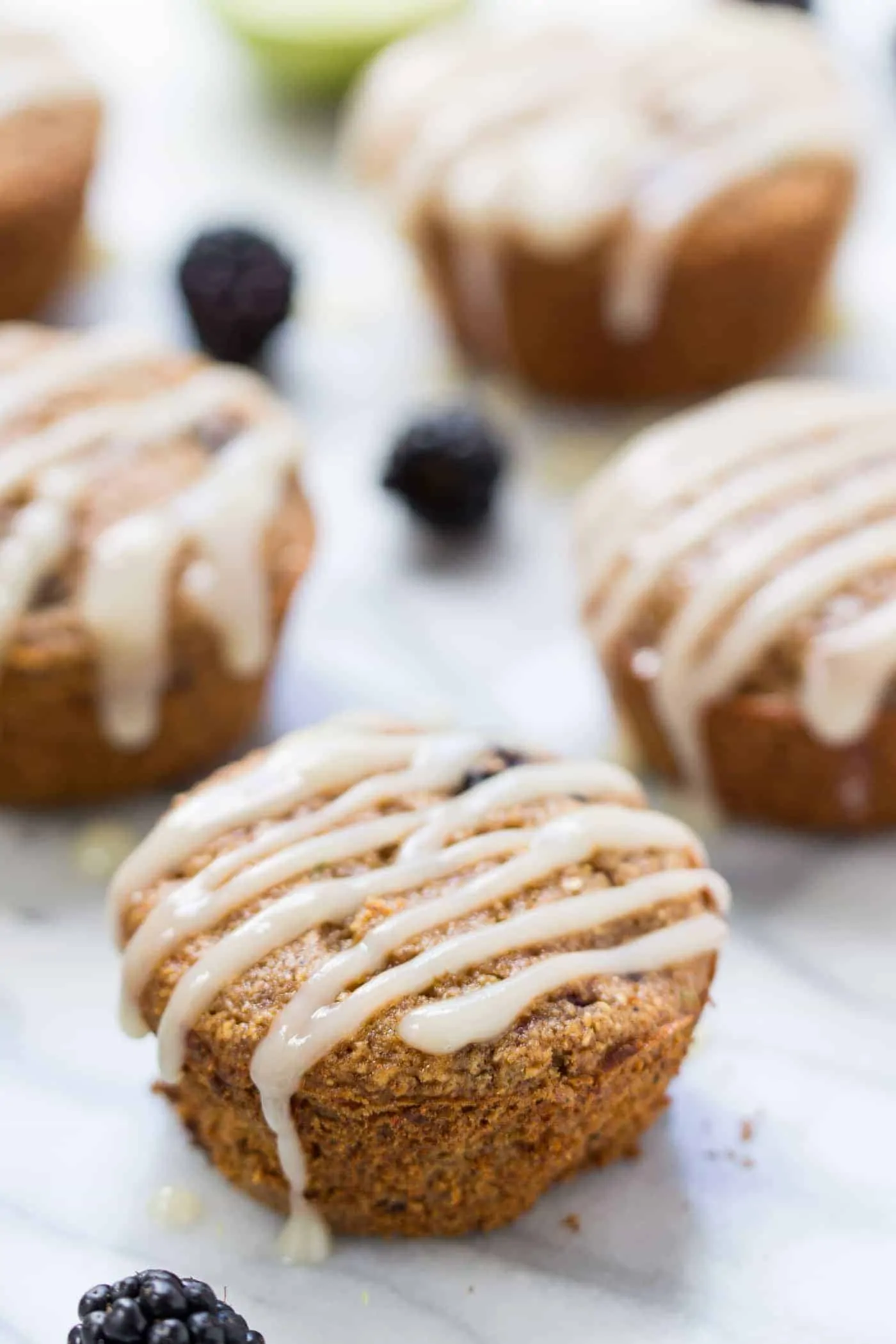 Blackberry Lime Oatmeal Muffins topped with a creamy coconut butter glaze! Naturally gluten-free, without any dairy, oils or eggs!