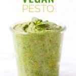 Title image for Vegan Pesto with vegan pesto in a glass jar next to a wooden spoon.