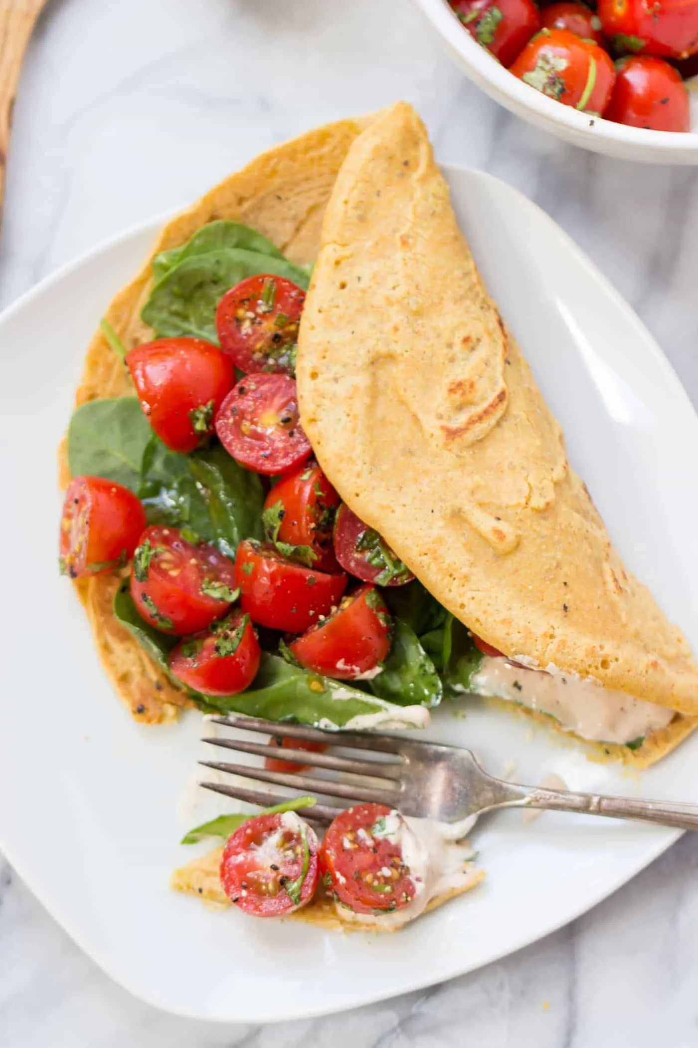 Savory Chickpea Pancakes served with a fresh tomato-cilantro salad and spinach!