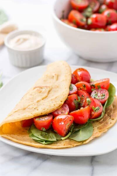Savory Chickpea Pancakes served with a fresh tomato-cilantro salad and spinach!
