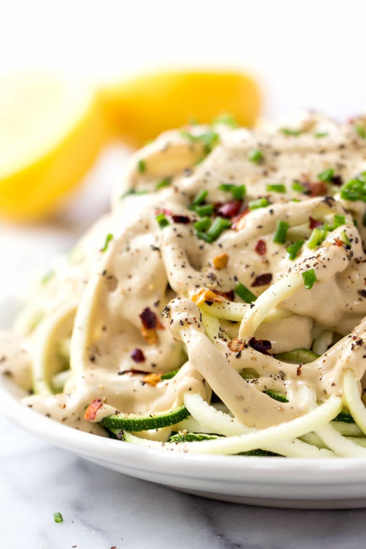 VEGAN LEMON CREAM SAUCE on top of spiralized zucchini noodles! A light and healthy dish that is burst with plant-based protein!