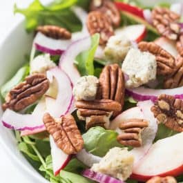 A super simple APPLE + PECAN ARUGULA SALAD topped with herbed cashew cheese and a maple-tahini dressing!