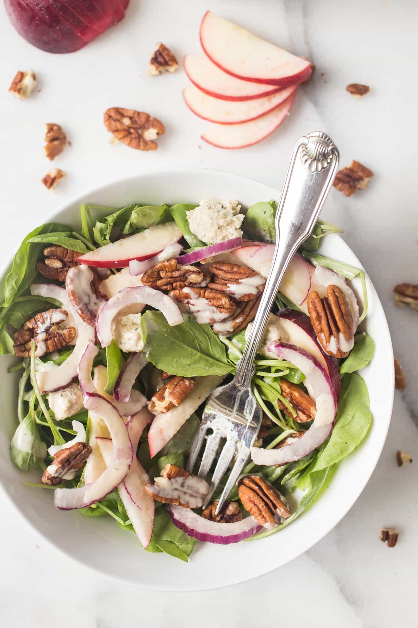 A super simple APPLE + PECAN ARUGULA SALAD topped with herbed cashew cheese and a maple-tahini dressing!