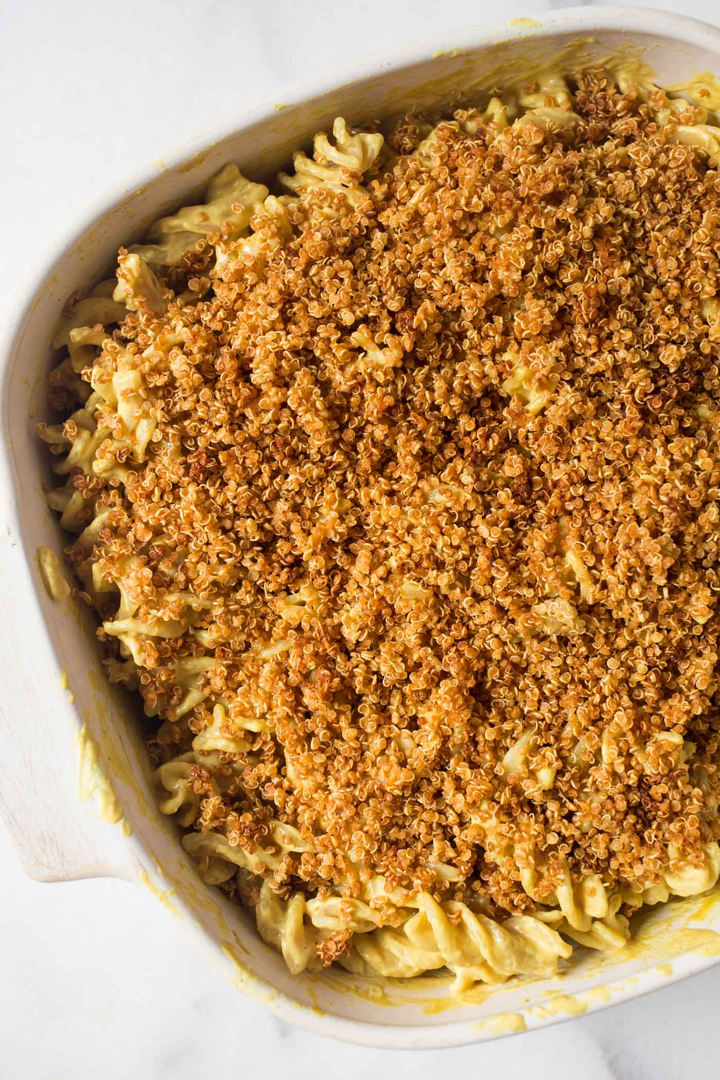Baked VEGAN Mac and Cheese with a dreamy "cheese" sauce and a crunchy quinoa topping!