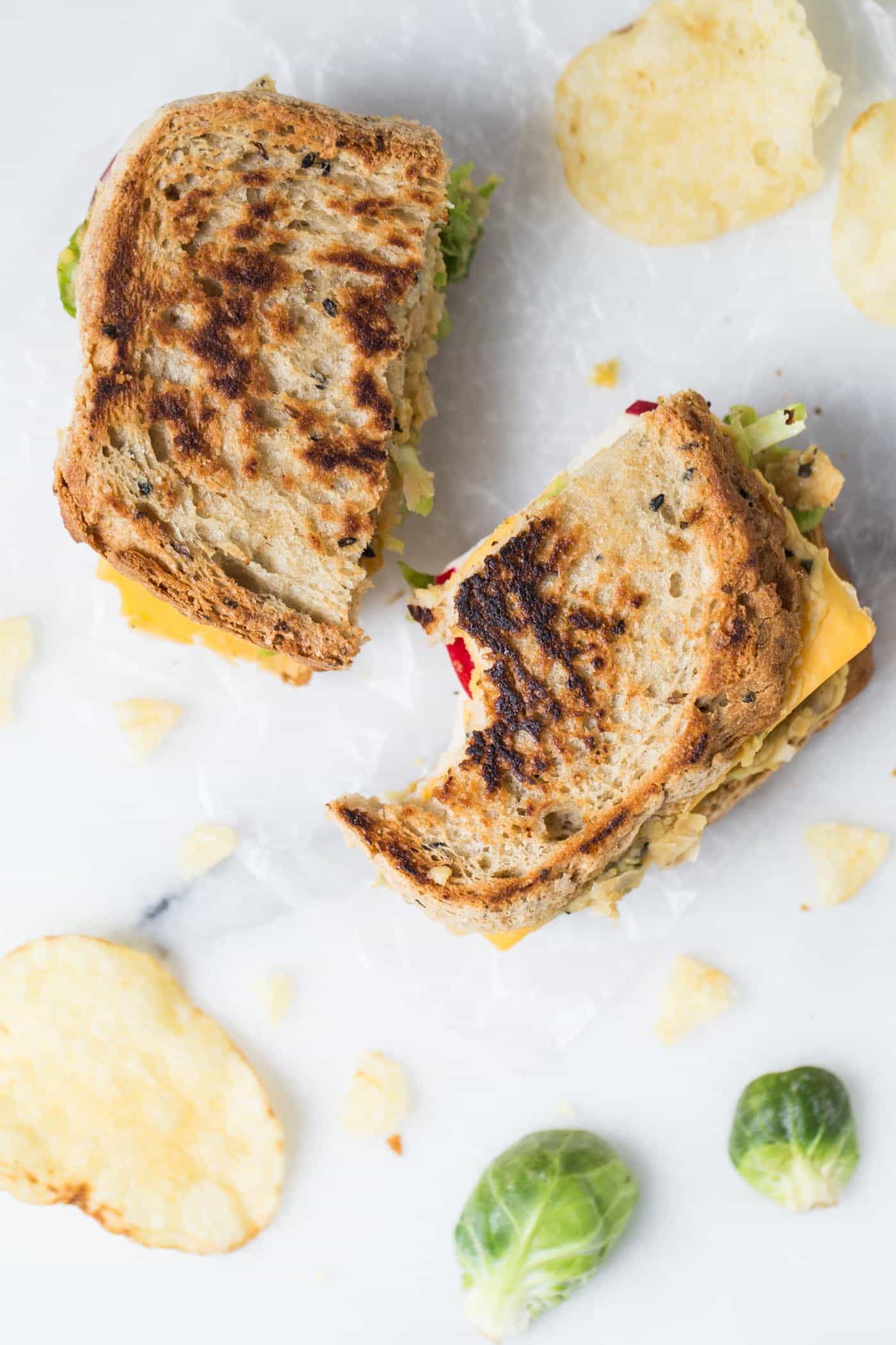 This is hands down THE BEST vegan grilled cheese ever! with brussels sprouts, hummus, apples and more!