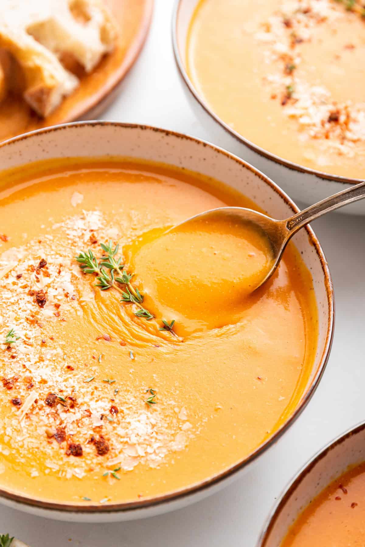 A spoon scooping some tomato bisque.