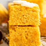 Two pieces of vegan pumpkin cornbread on top of each other, with a pat of butter on top